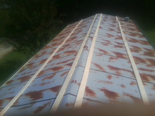 Rusted metal roof panels with new wood purlins before replacement — Storm Damage Roof Repair in Manchaca by Roofing Brothers