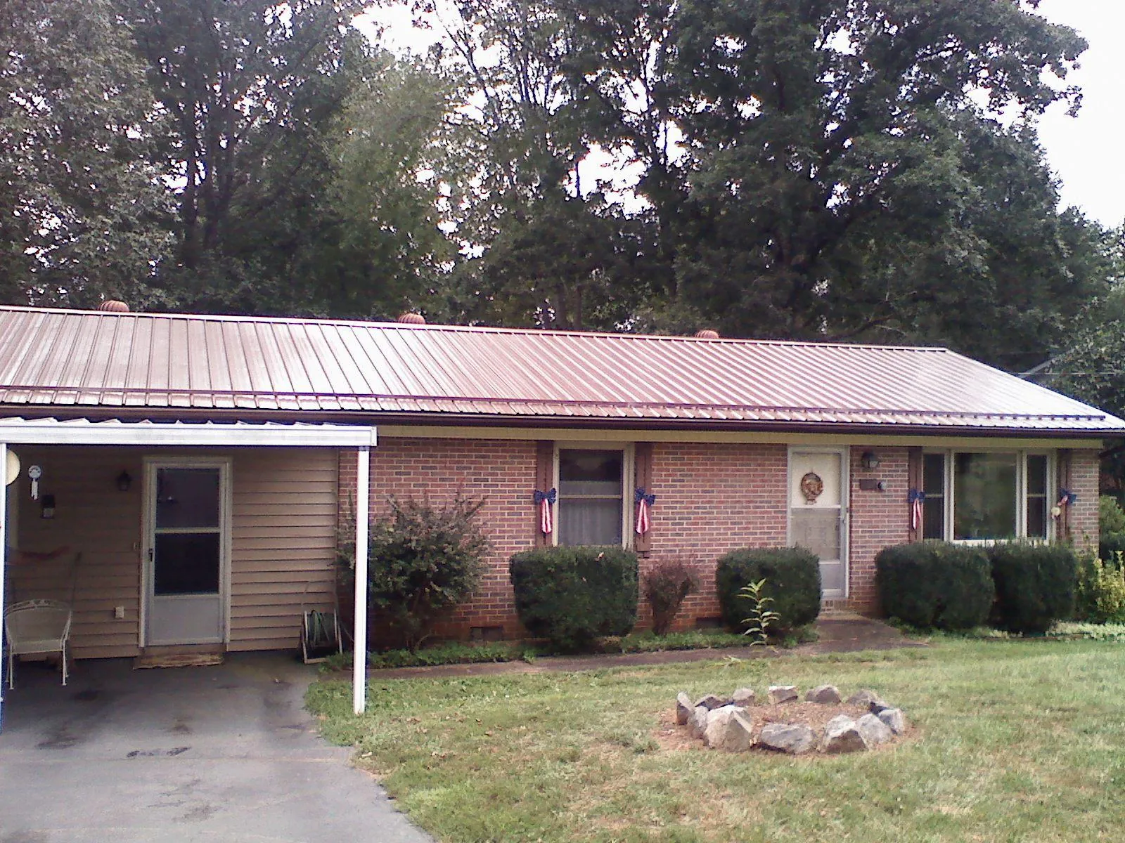 Bronze metal roof and carport on a brick ranch home — Roof Repair work by our crew in Manchaca