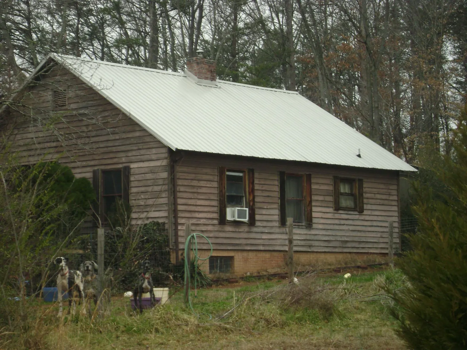 White metal roof on an old wood sided farmhouse, from a Asphalt Shingle Roof Repair job in Manchaca
